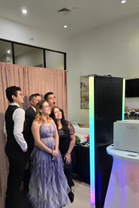 Guests smiling and having fun using the Mirror Photo Booth with colorful props and interactive animations.